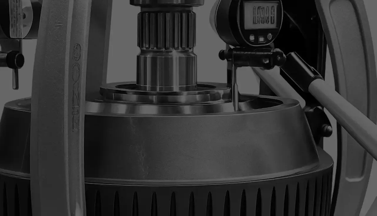 Schwarz-weiße Aufnahme einer Industriemaschine mit Zahnrädern, digitalem Display und Messinstrumenten.